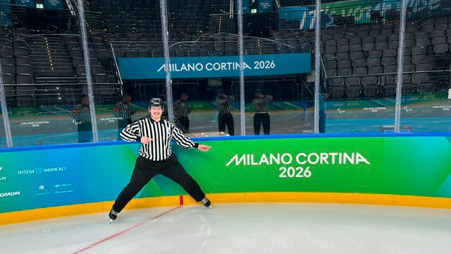 Lari Niittylä poseeraamassa kameralle Milano-Cortinan 2026 jääkiekkokaukalossa tuomarivarustuksessa.